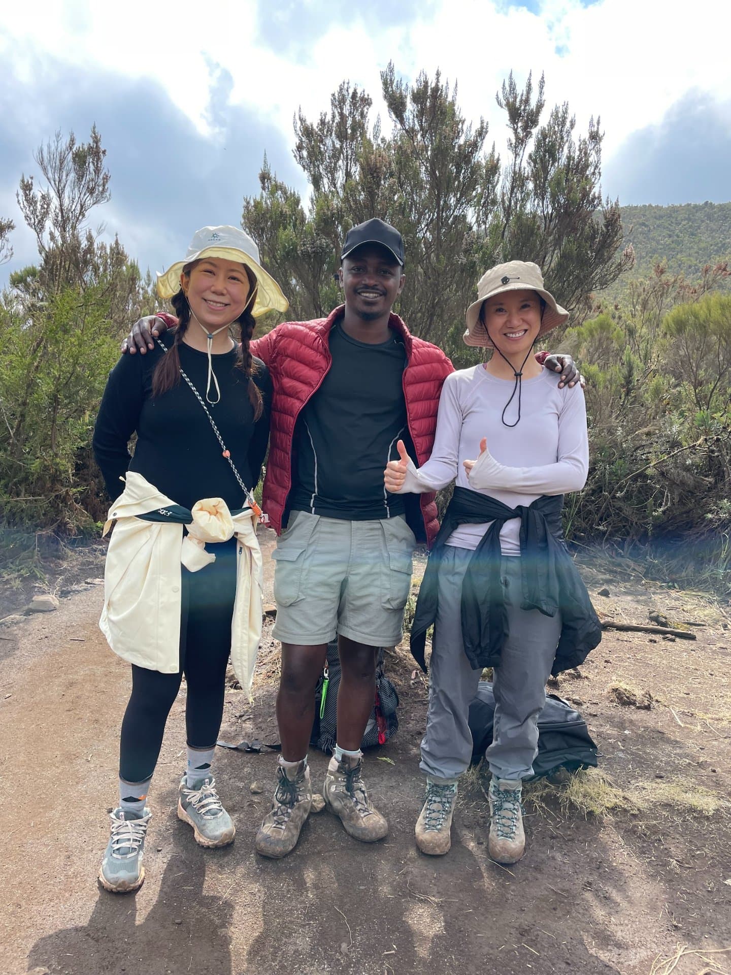 Fundador da Climb2Kili Aventuras em pé com clientes no Monte Kilimanjaro